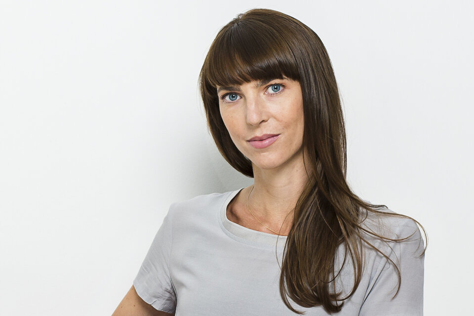 Porträt von Designerin Judith Bergmann vor weißer Wand.